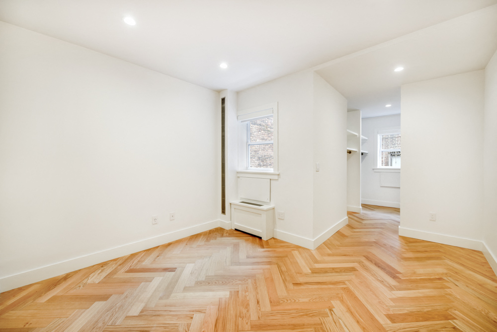 a living room with a hardwood floor and white walls